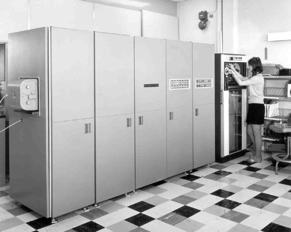 Hardcopy Camera on the SC4020, showing a computer the size of 5 refrigerators side by side being operated by a woman.