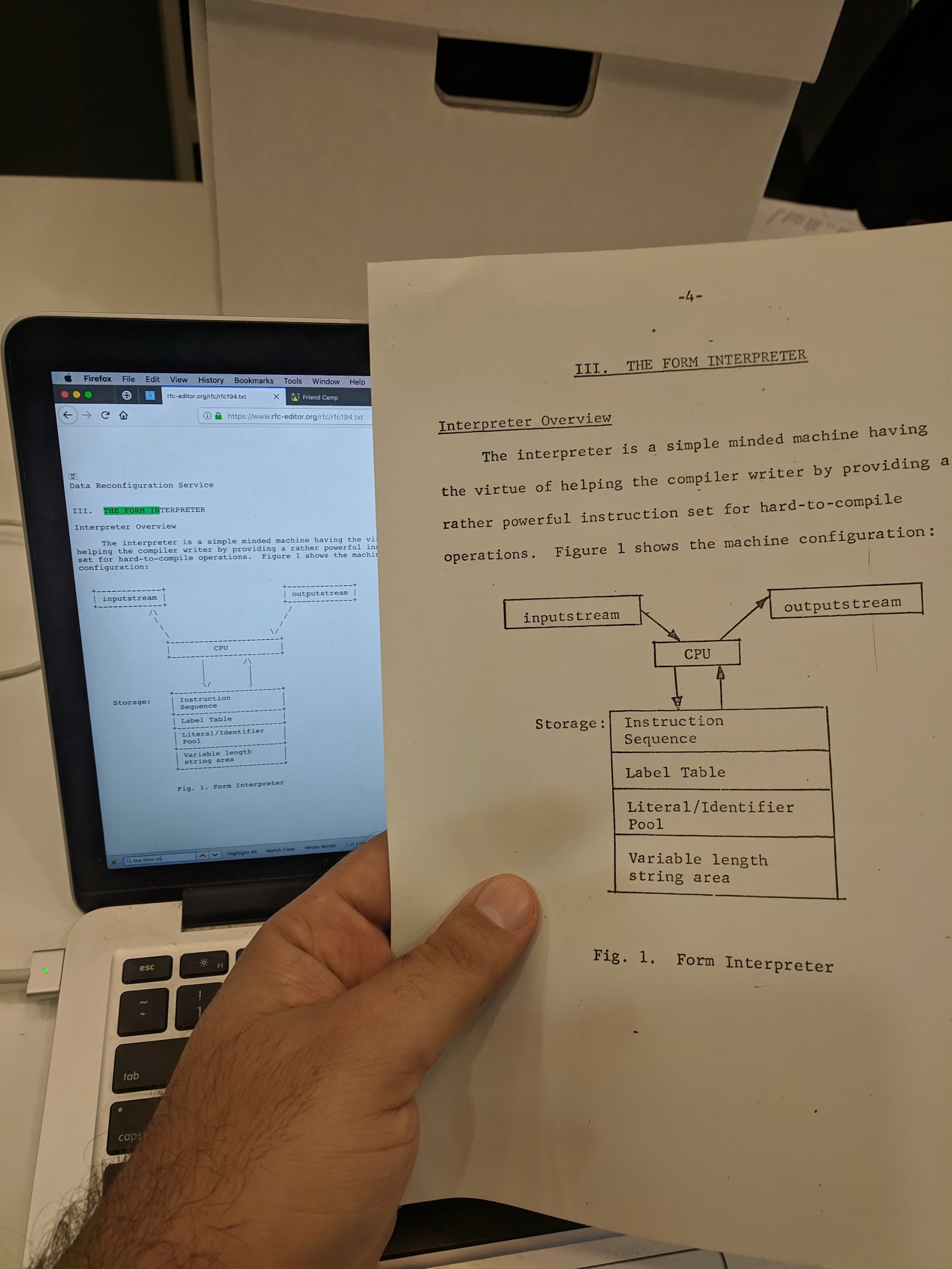 Photo of a paper document held next a computer monitor, showing the discrepancy described above.